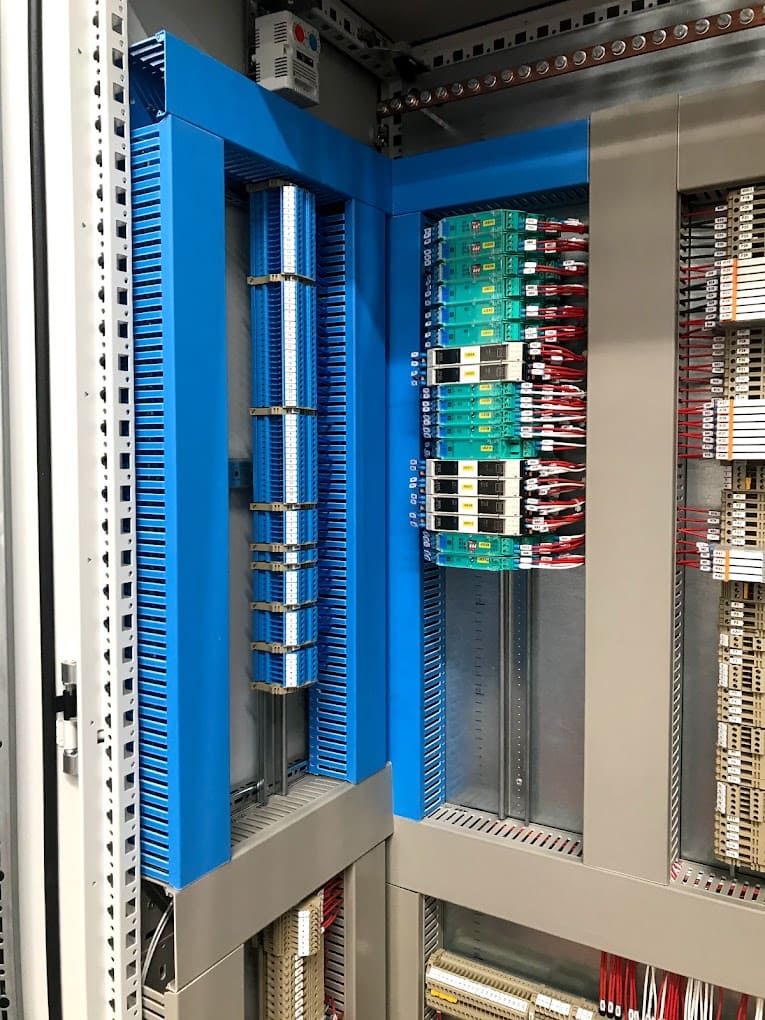 Cableado estructurado dentro de un gabinete de distribución eléctrica con paneles de color azul.