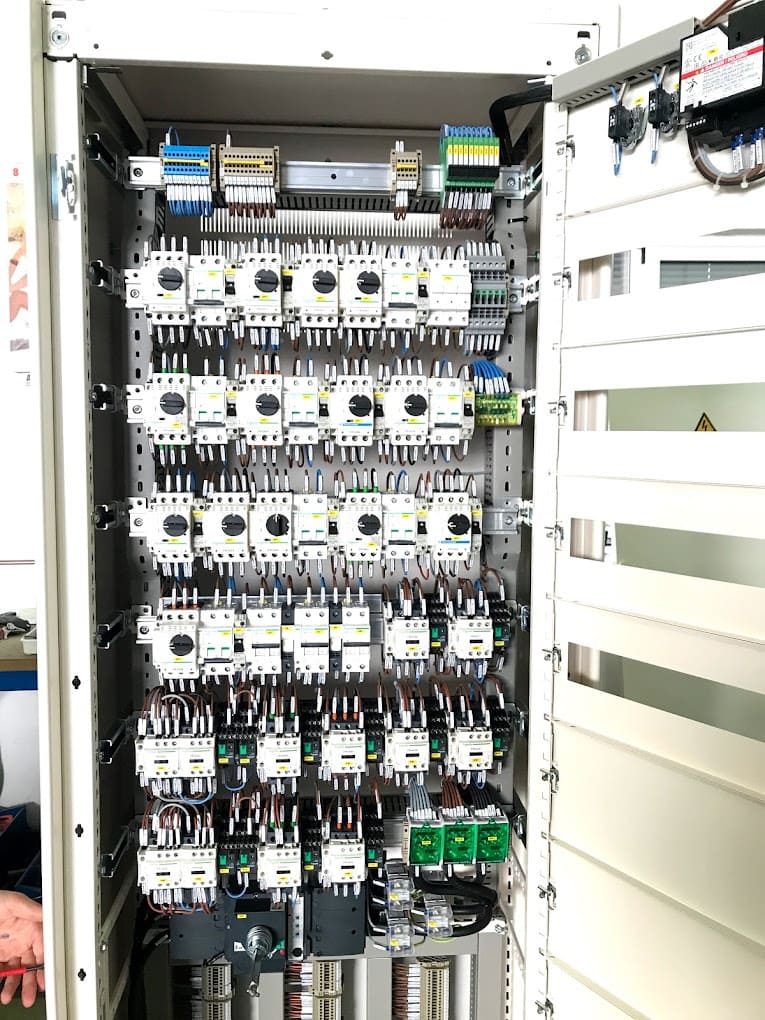 Panel de distribución eléctrica con múltiples disyuntores y conexiones.