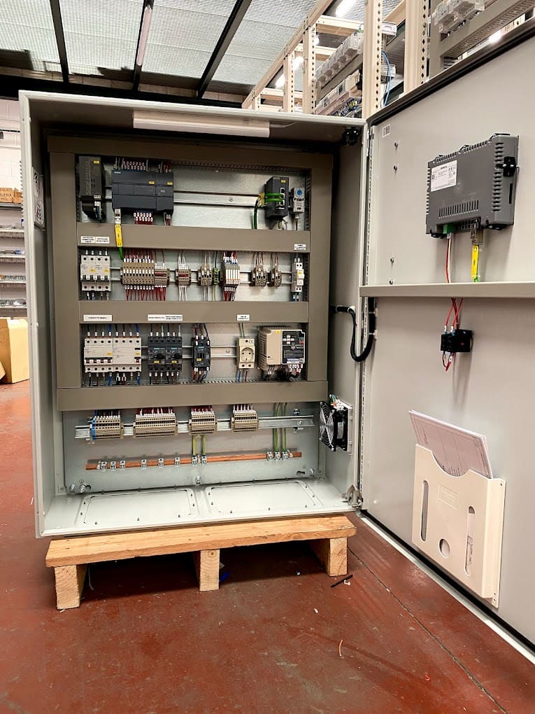 Gabinete eléctrico abierto en un almacén, mostrando su configuración interna.